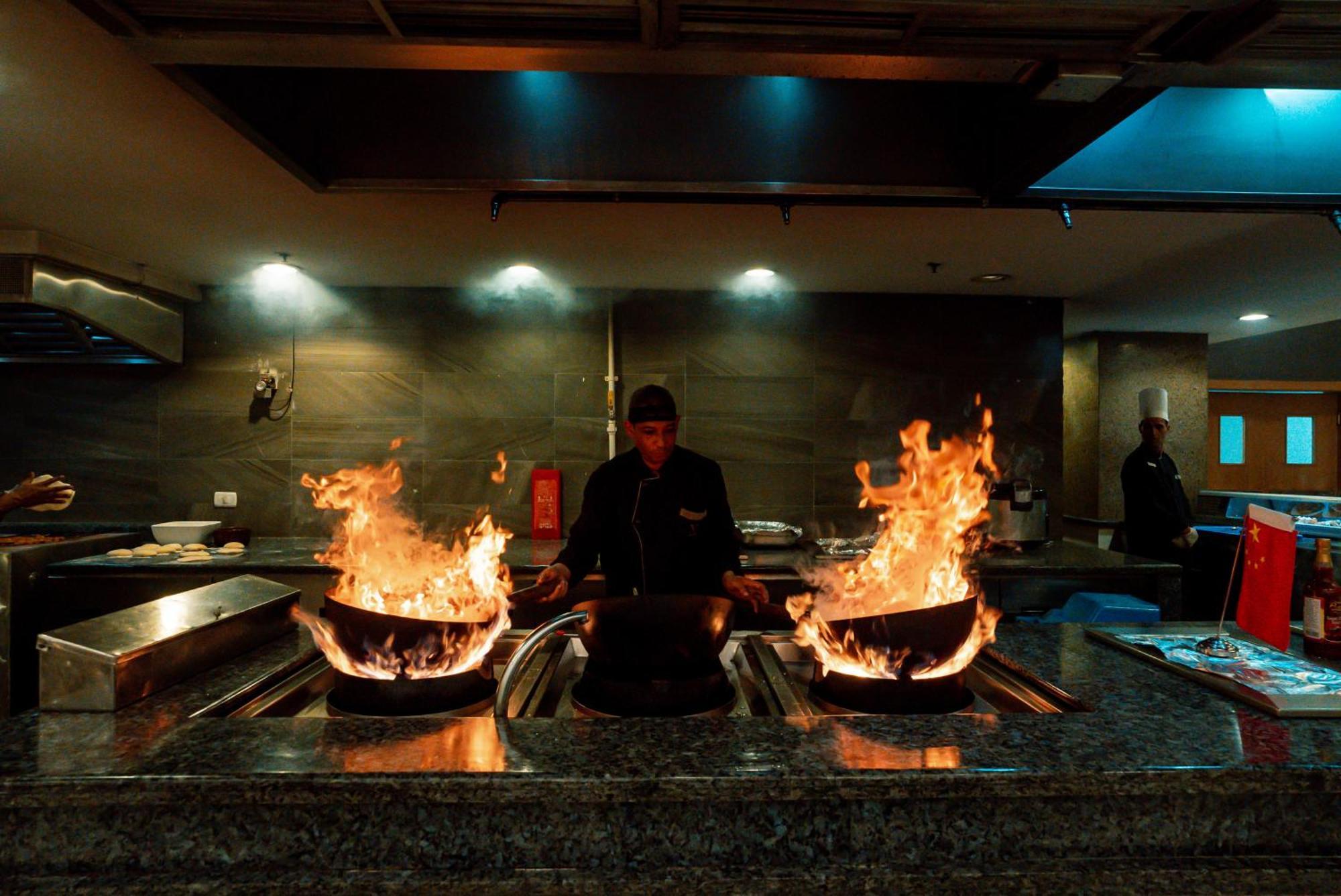 The V Luxury Resort Sahl Hasheesh Hurgada Dış mekan fotoğraf A chef cooking with a wok
