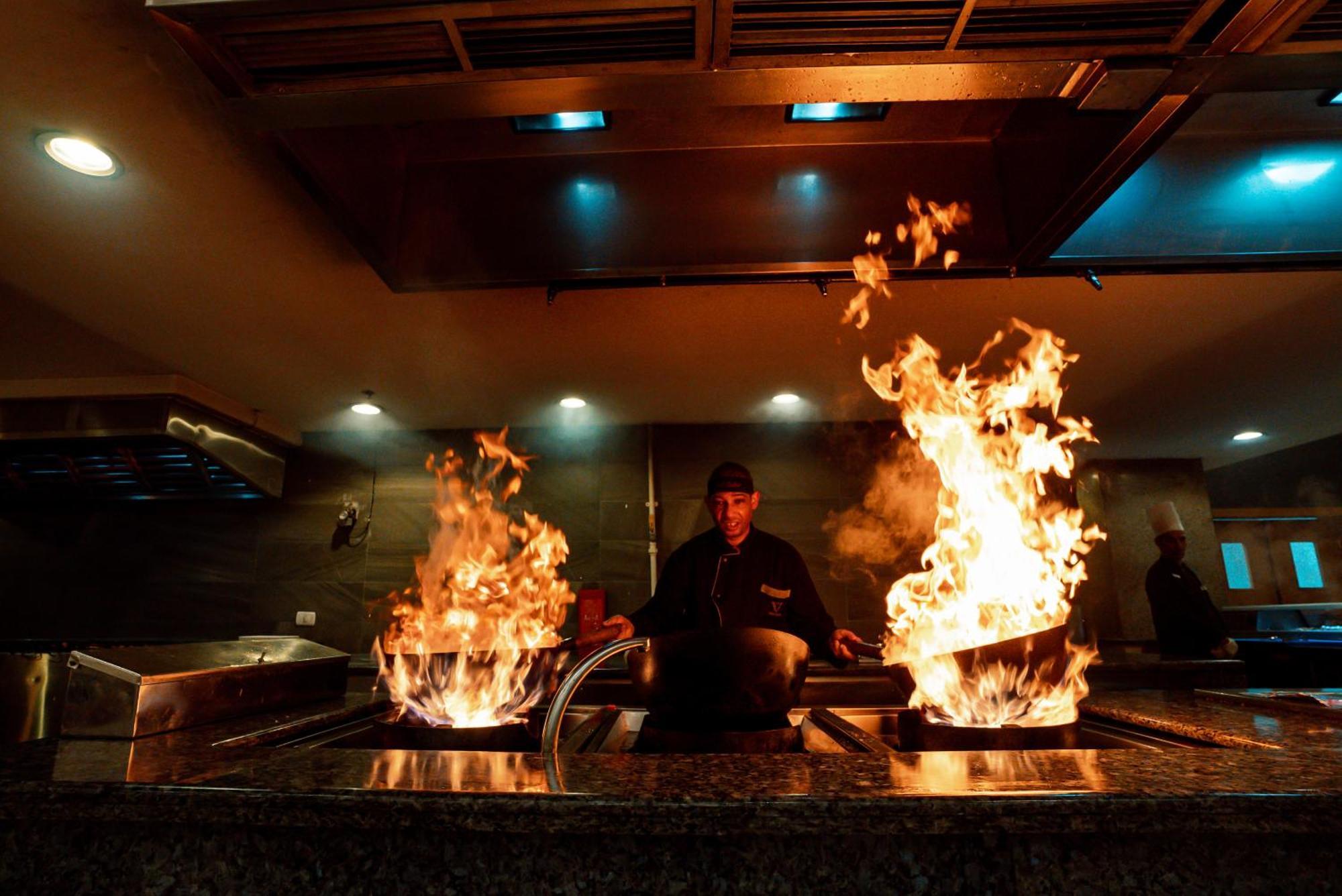 The V Luxury Resort Sahl Hasheesh Hurgada Dış mekan fotoğraf A chef cooking with a wok